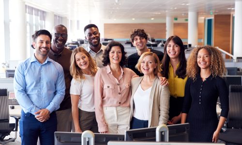 Portrait Of Smiling Business Team Working In Modern Office Together